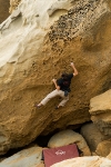 Rock climber Kevin Jorgeson ascending a sandstone boulder at Salt Point State Park, Sonoma Coast, Calfornia